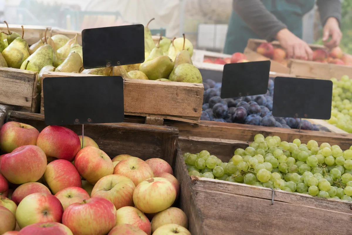 Étal de marché avec cagettes de fruits français de saison